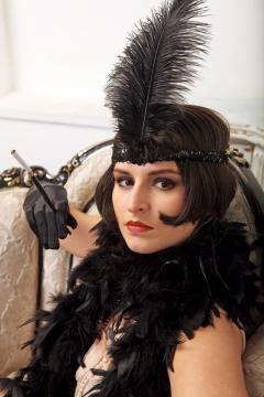 Woman with a feather in her hat and wearing a feather boa. Image By Maria Grin on Shutterstock.com